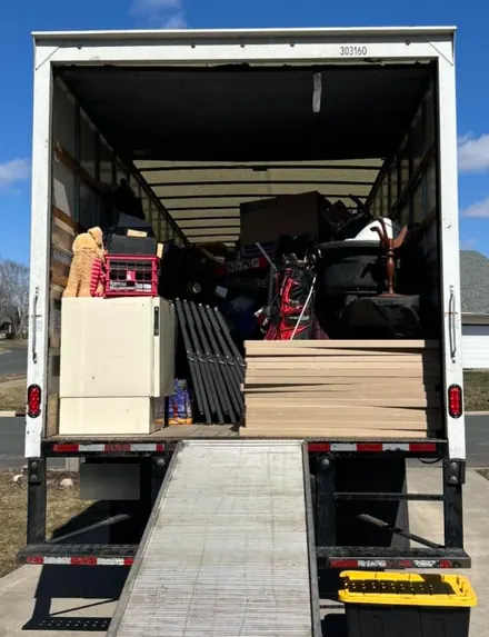 Box truck loaded with boxes, a white cabinet, a golf bag and stacked boards